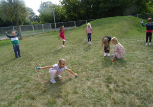 dziewczynki skaczą na skakance na trawie